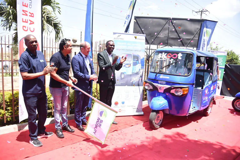 People celebrating launch of electric three wheeler